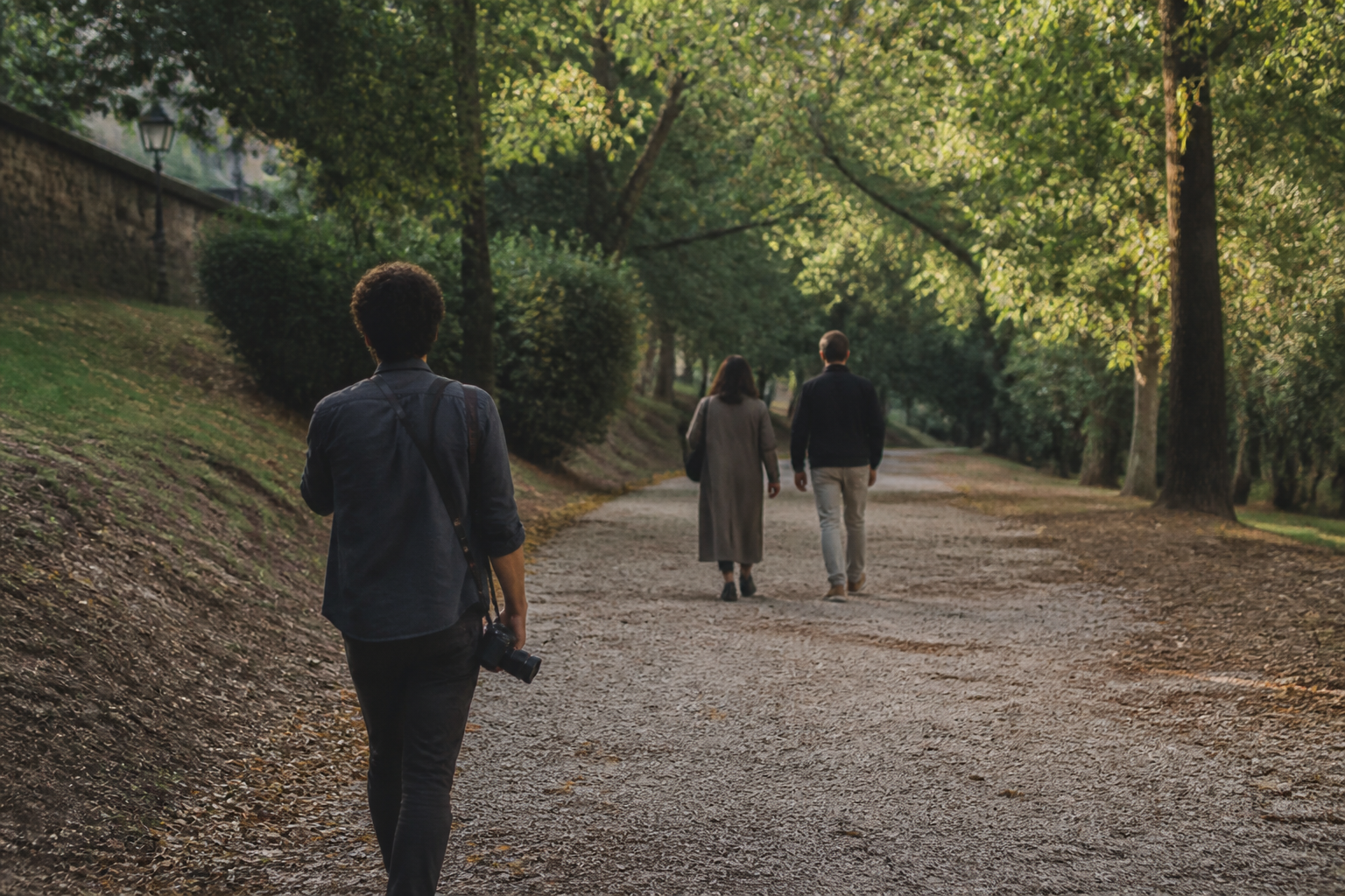 Fotografo che segue una coppia in un parco durante una sessione all'aperto