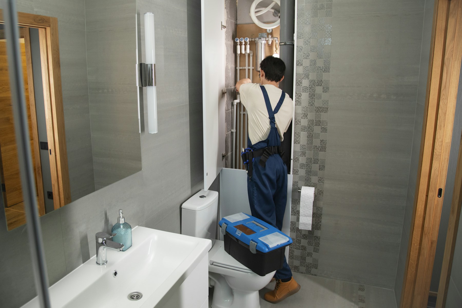 Tecnico al lavoro su un impianto idraulico in bagno